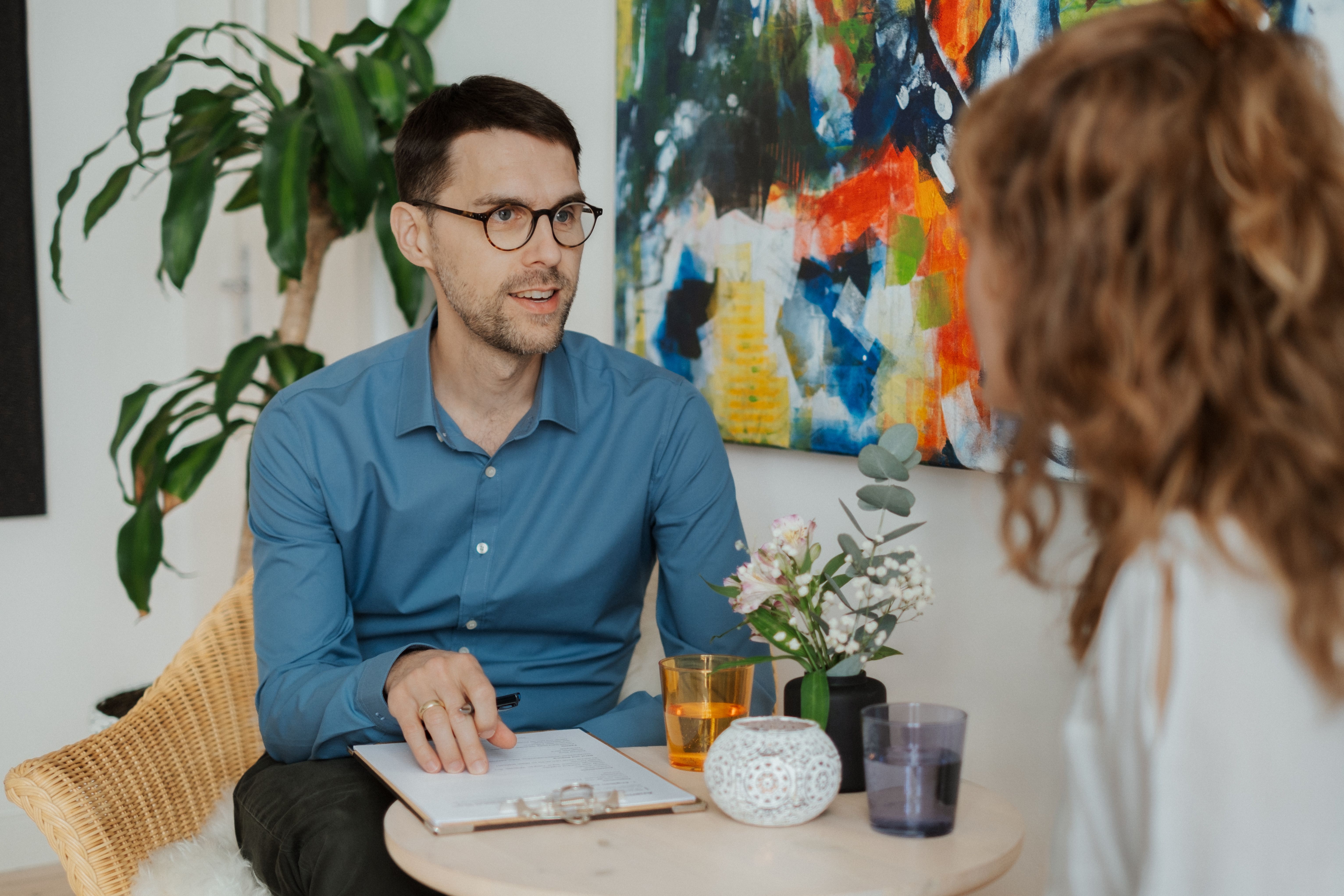 Lasse Schwarten im konzentrierten Gespräch mit einer Klientin in seiner Praxis